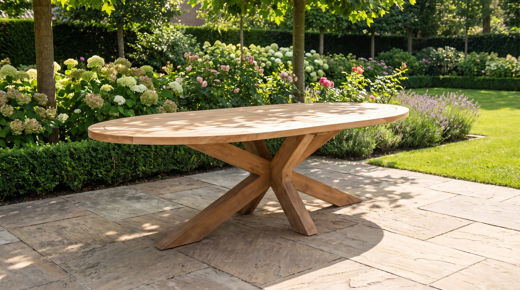 Ovale teakhouten tuintafel op een schaduwrijk terras in de vroege ochtend
