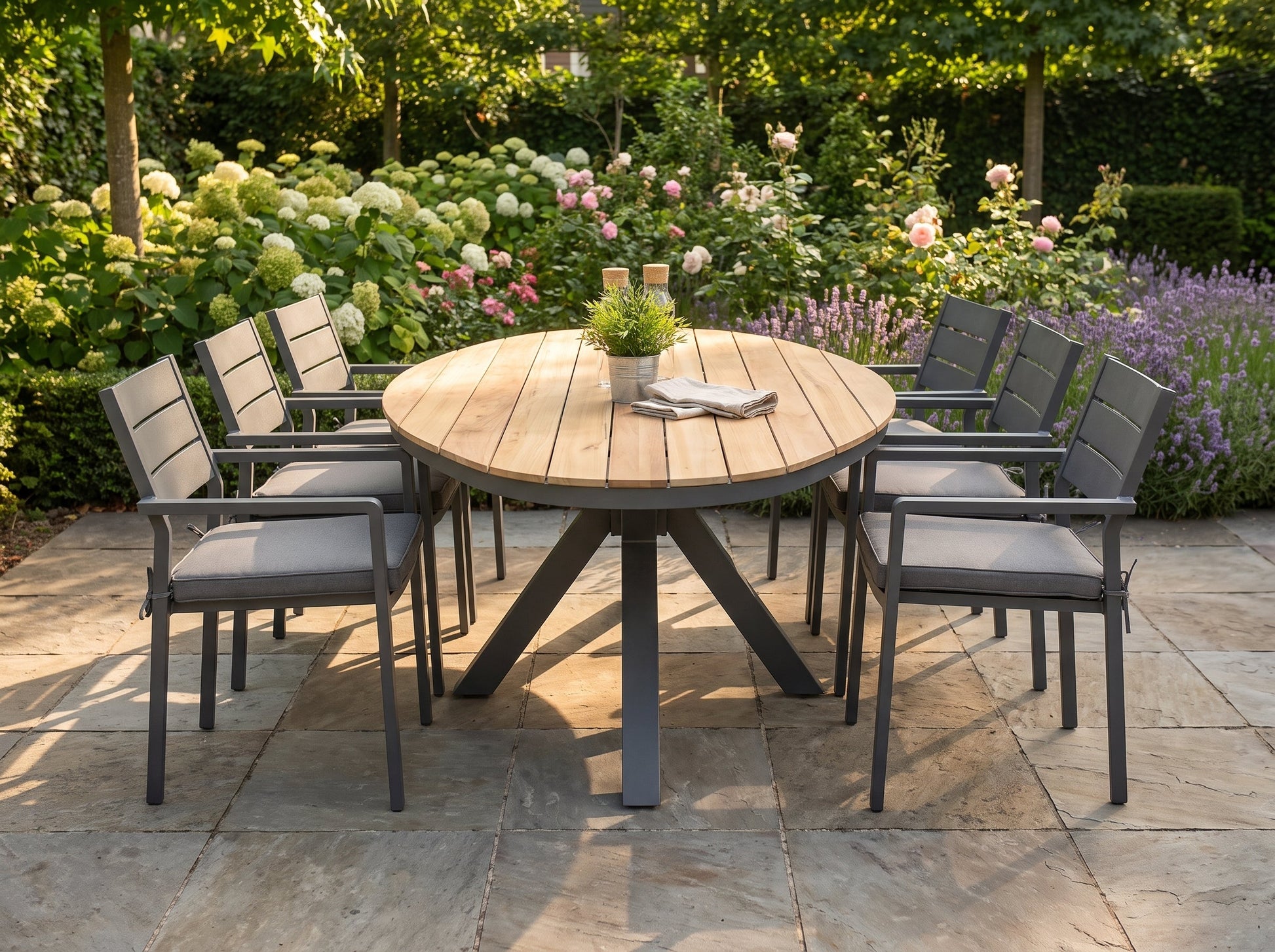 Akron-Bolton Tuinset 6 Personen - Teak / Dark Grey in einem stimmungsvollen Garten - Outnest Gartenmöbel