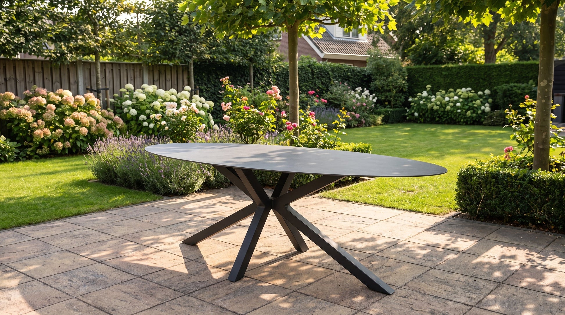 Ovaler Gartentisch, gedeckt für ein Mittagessen auf einer sonnigen Terrasse