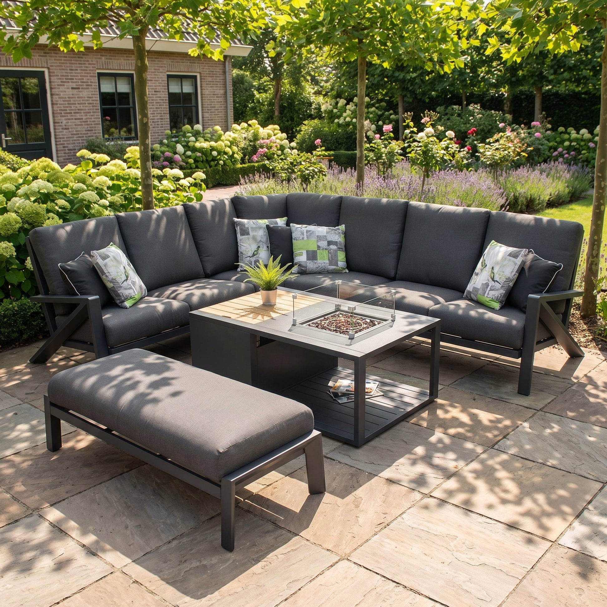 Carini Eck-Loungeset Black mit Feuertisch in einem stimmungsvollen Garten