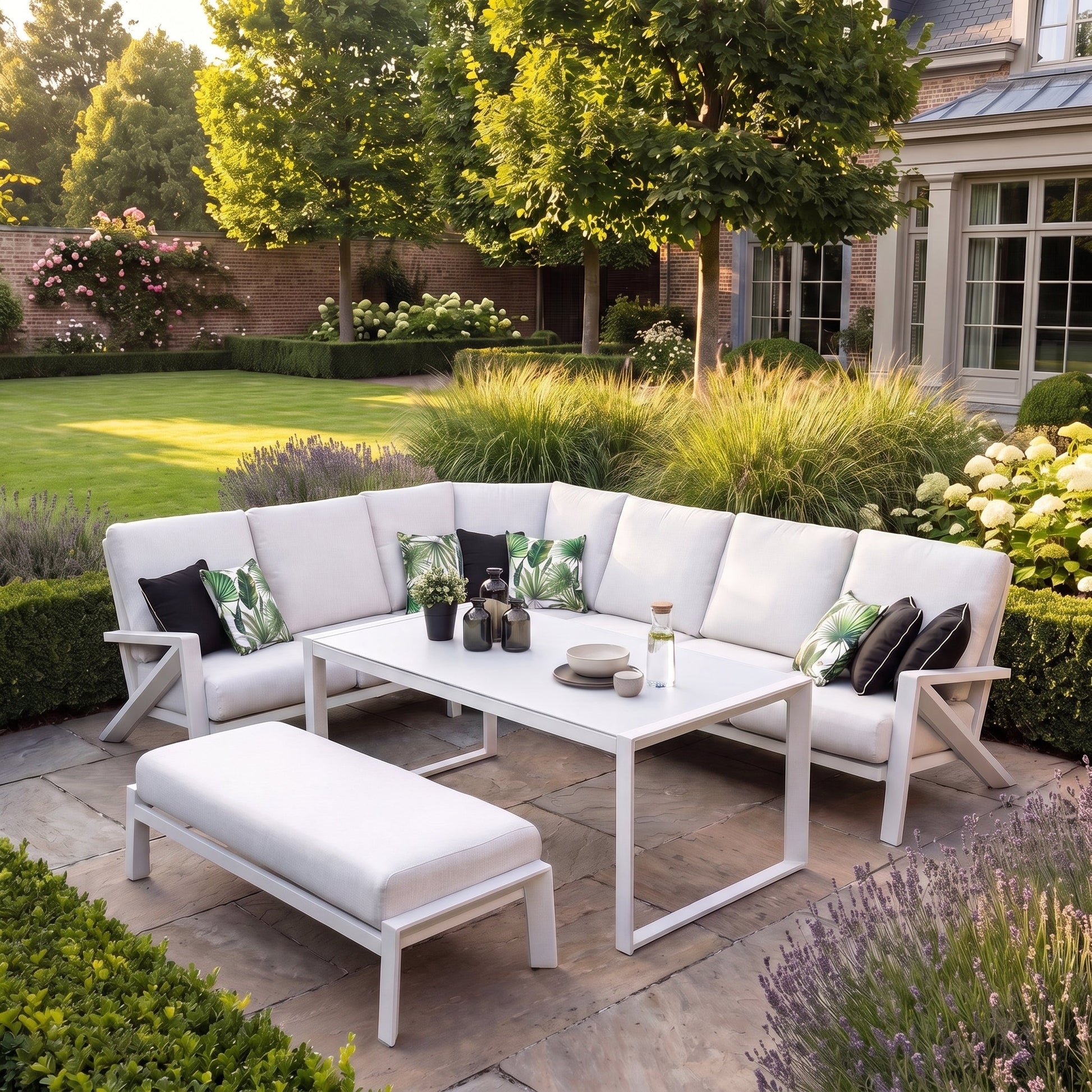 Carini Eck-Loungeset White mit hohem Tisch in einem stimmungsvollen Garten