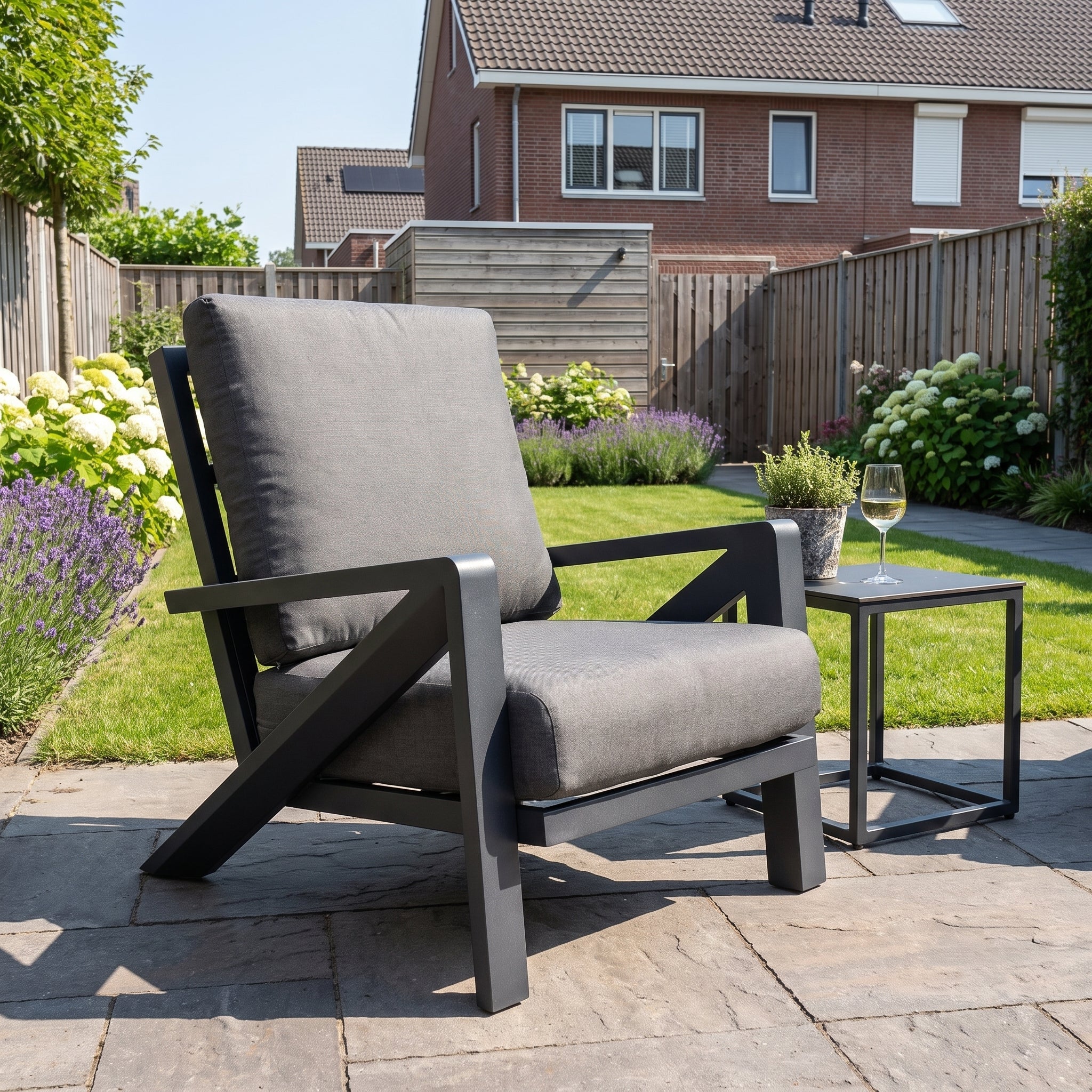 Carini Loungestoel - Black in einem stimmungsvollen Garten - Outnest Gartenmöbel