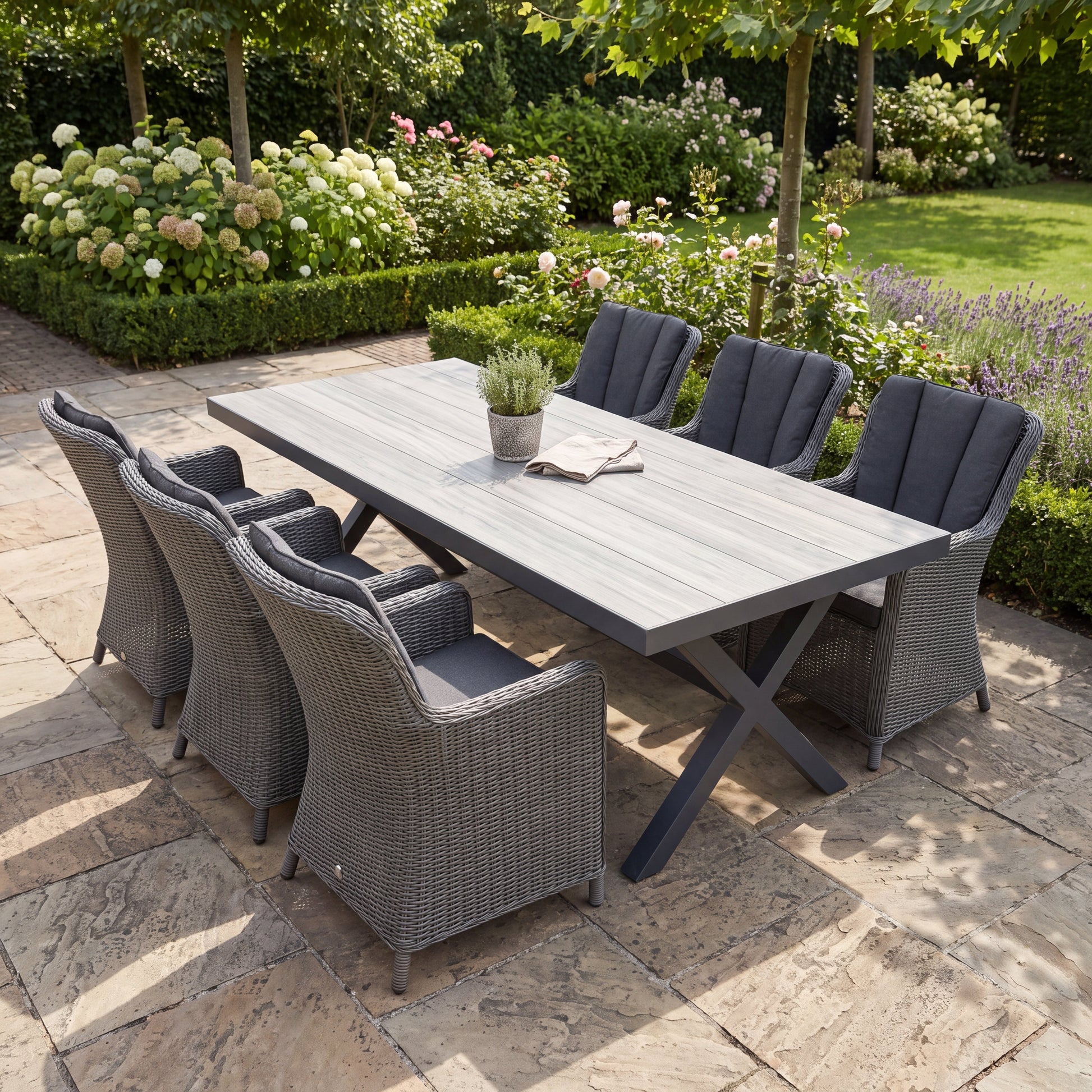 Costana-Avalon Gartenset 6 Personen mit Ausziehtisch mit hellgrauer Keramikplatte in Holzoptik und sechs Avalon Rock Grey Wicker-Sesseln auf einer Terrasse - Outnest Gartenmöbel