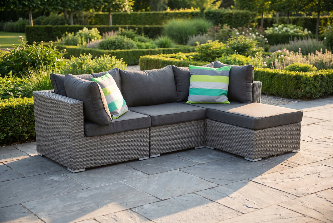 Aluminium loungeset met kunststof vlechtwerk in een tuin bij lichte motregen onder een parasol