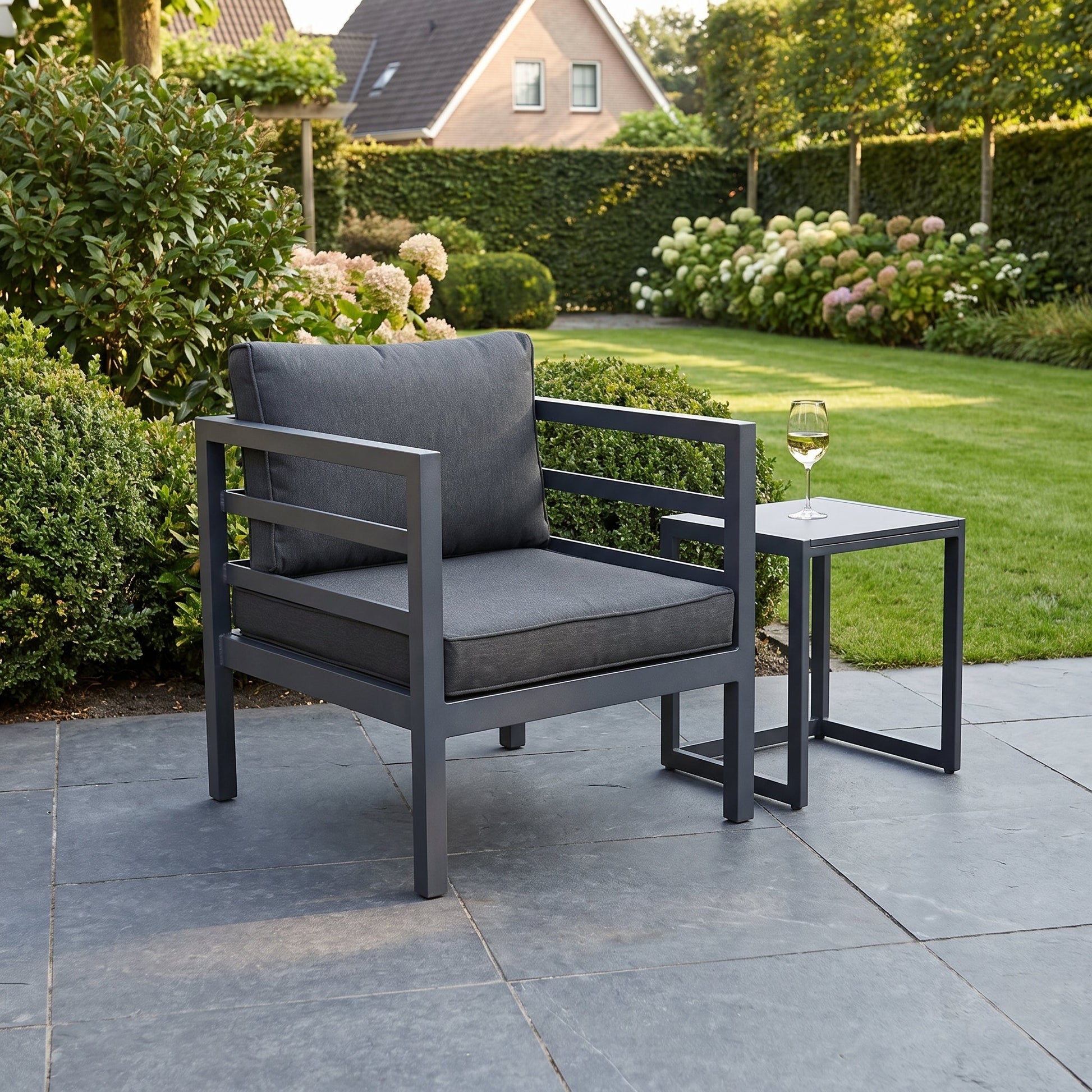 Nevada Loungestoel - Dark Grey in einem stimmungsvollen Garten - Outnest Gartenmöbel