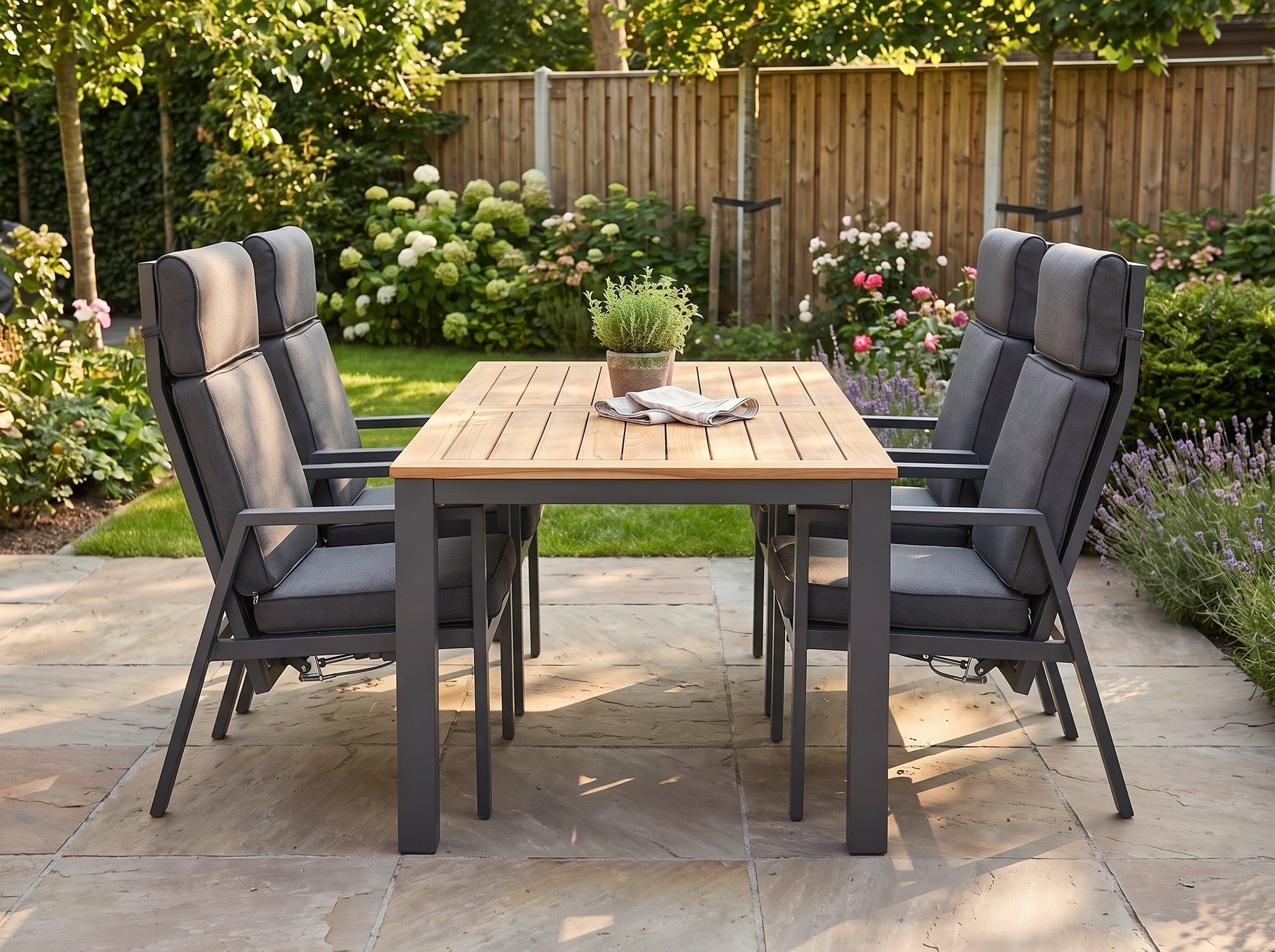 Birmingham Verstelbare Tuinset 4 Personen - Teak / Dark Grey in einem stimmungsvollen Garten - Outnest Gartenmöbel