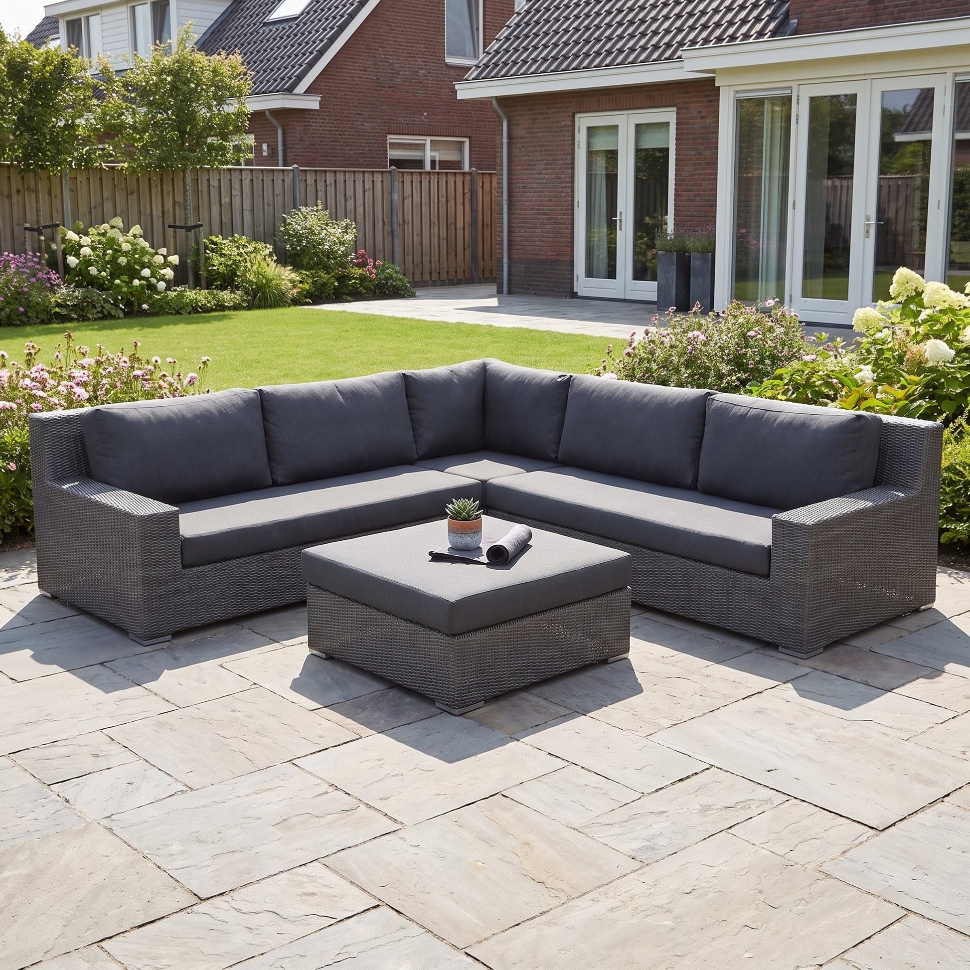 Riga Hoek Loungeset - Rock Grey in einem stimmungsvollen Garten - Outnest Gartenmöbel